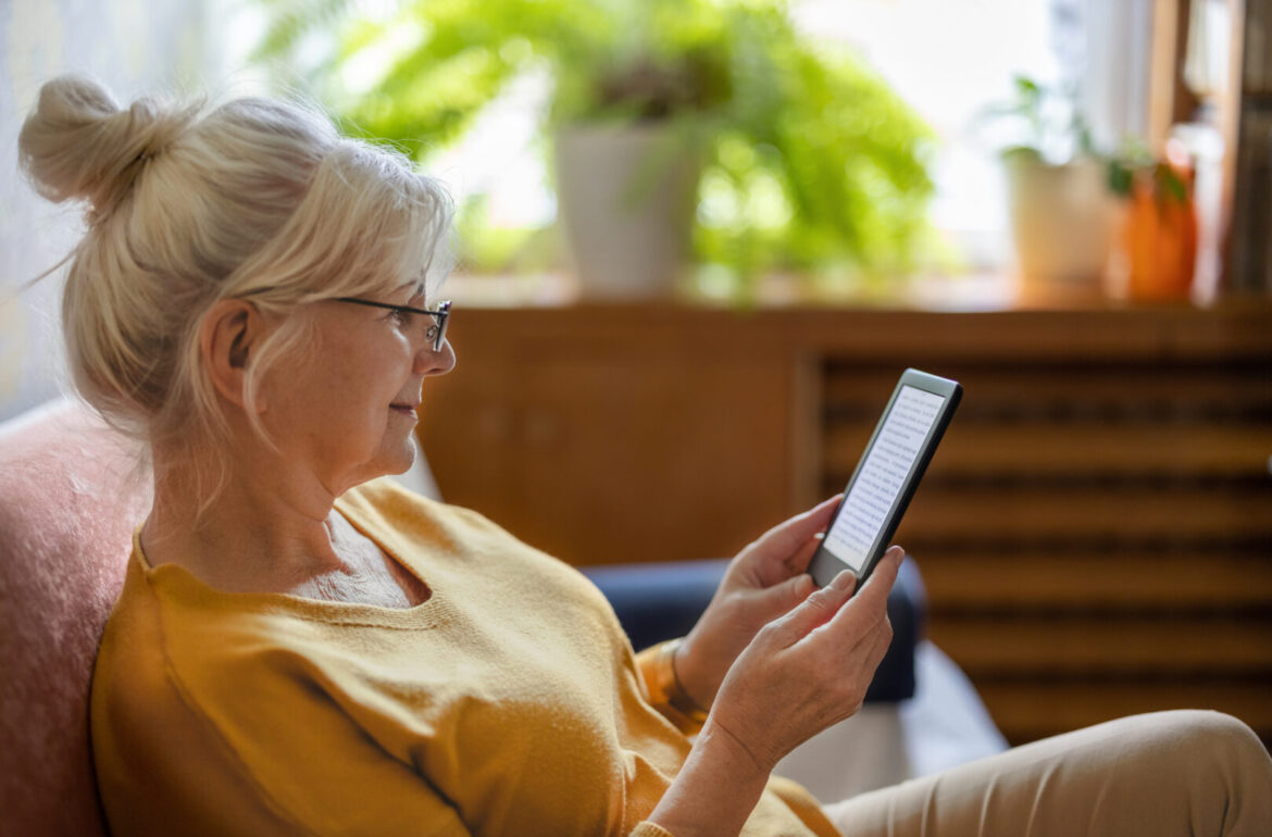 mature woman with presbyopia using glasses to read a tablet
