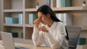 why are my eyes burning; Asian business woman suffering from burning eyes at work
